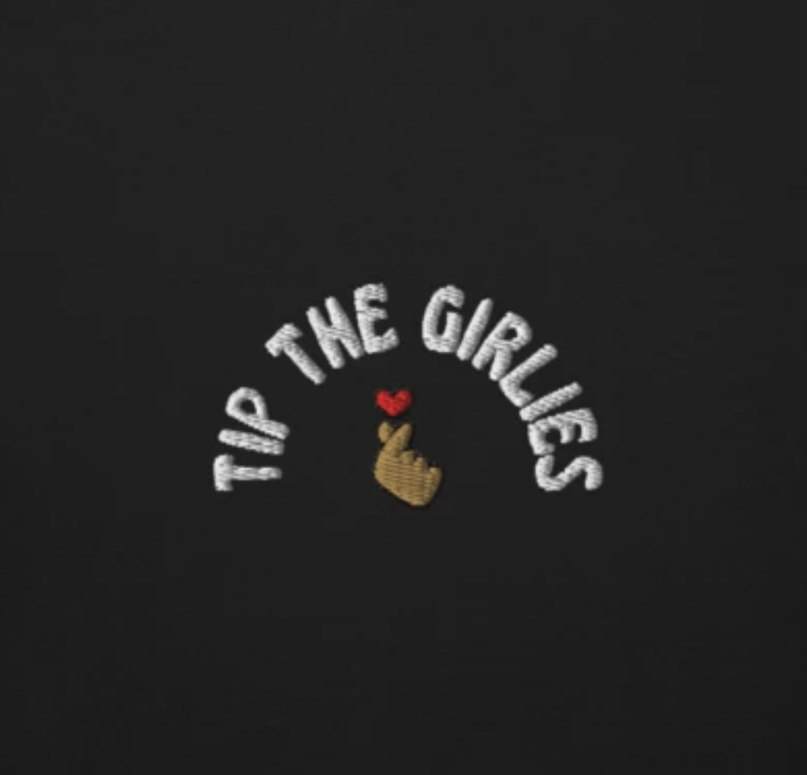 Closeup of an embroidery with the words "Tip the Girlies"