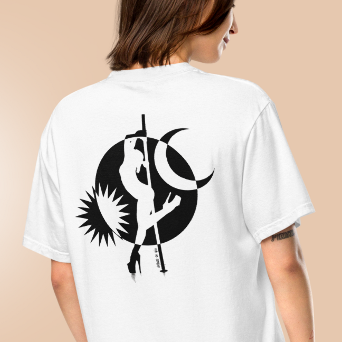 Woman facing away from the camera wearing a white tshirt with a black and white design of a pole dancer.
