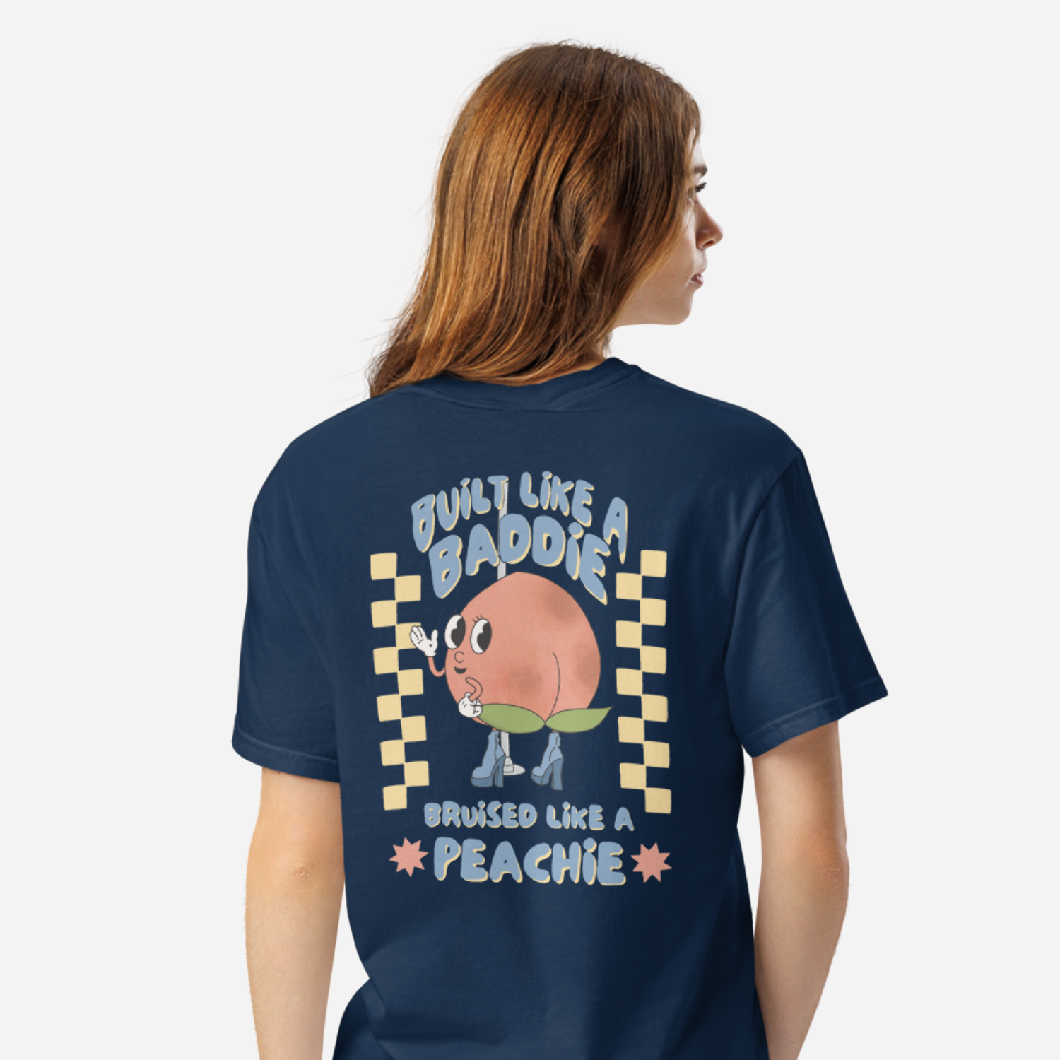 Woman facing the back wearing a navy tshirt with a graphic of a cartoon peach. It says 
