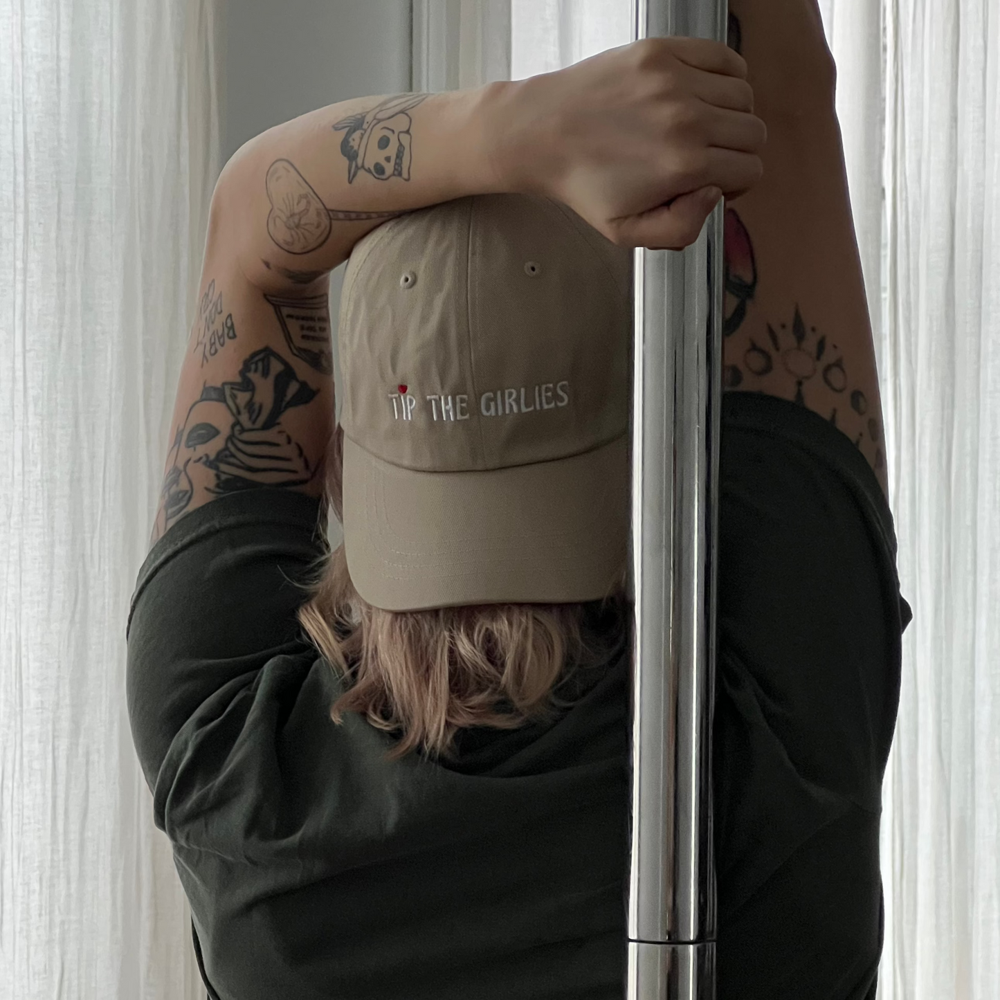 Woman wearing a beige Tip the Girlies hat, facing away from the camera, holding a pole.