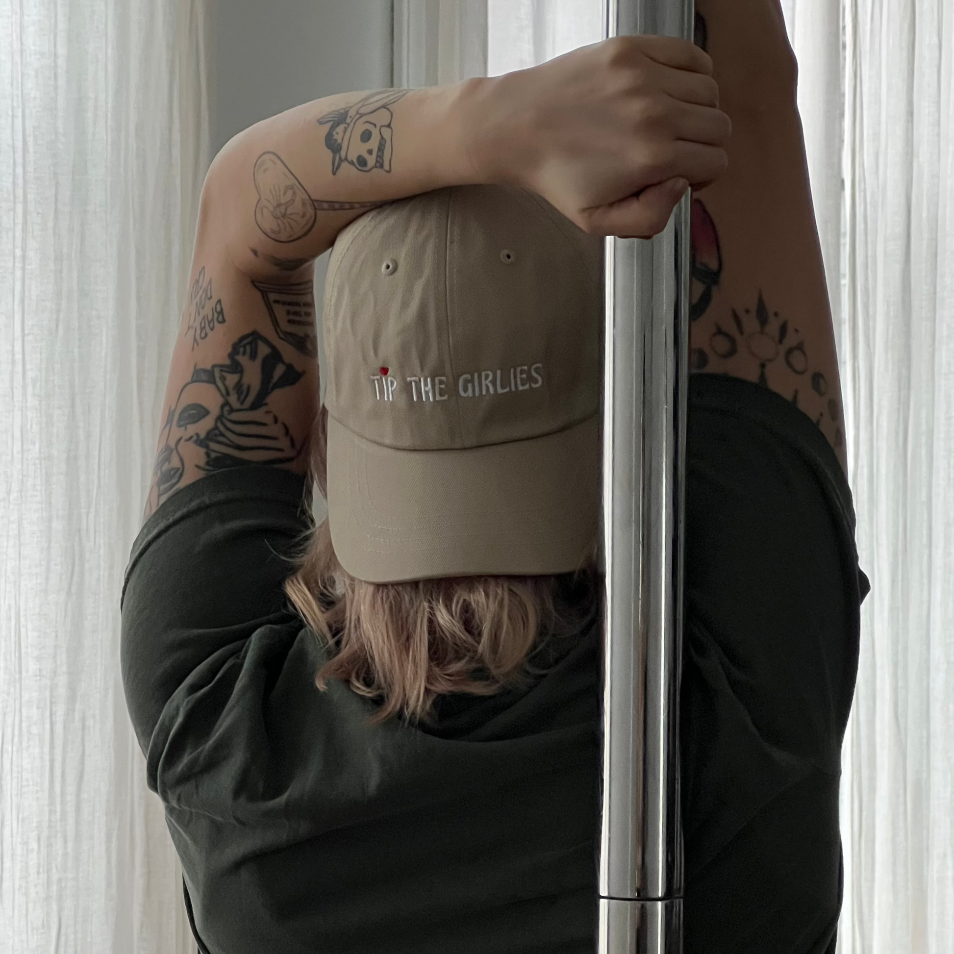 Woman wearing a beige Tip the Girlies hat, facing away from the camera, holding a pole.