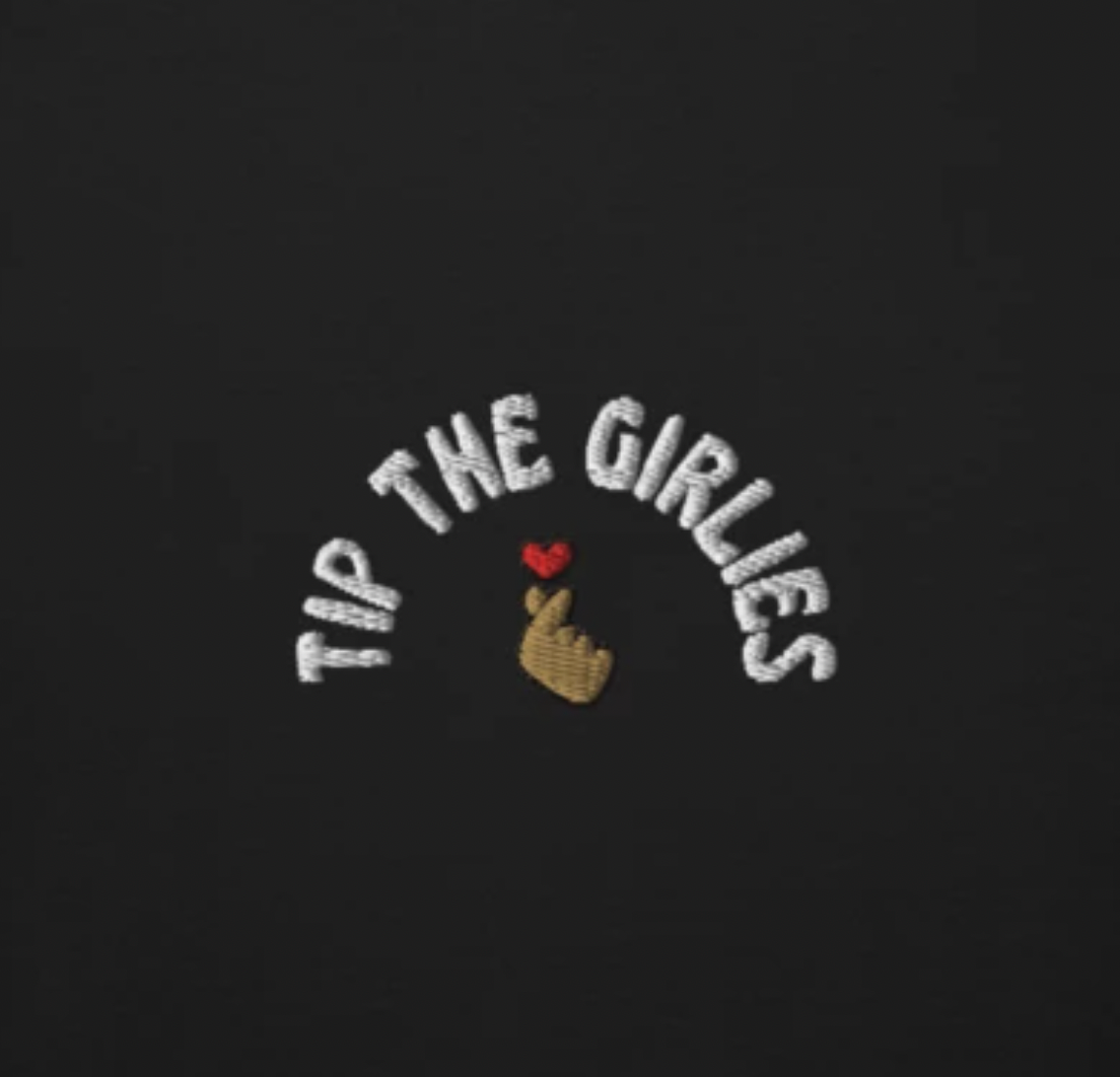 Closeup of an embroidery with the words "Tip the Girlies" 