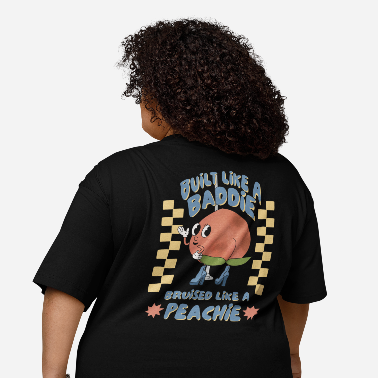 Person facing the back wearing a black tshirt with a graphic of a cartoon peach. It says 