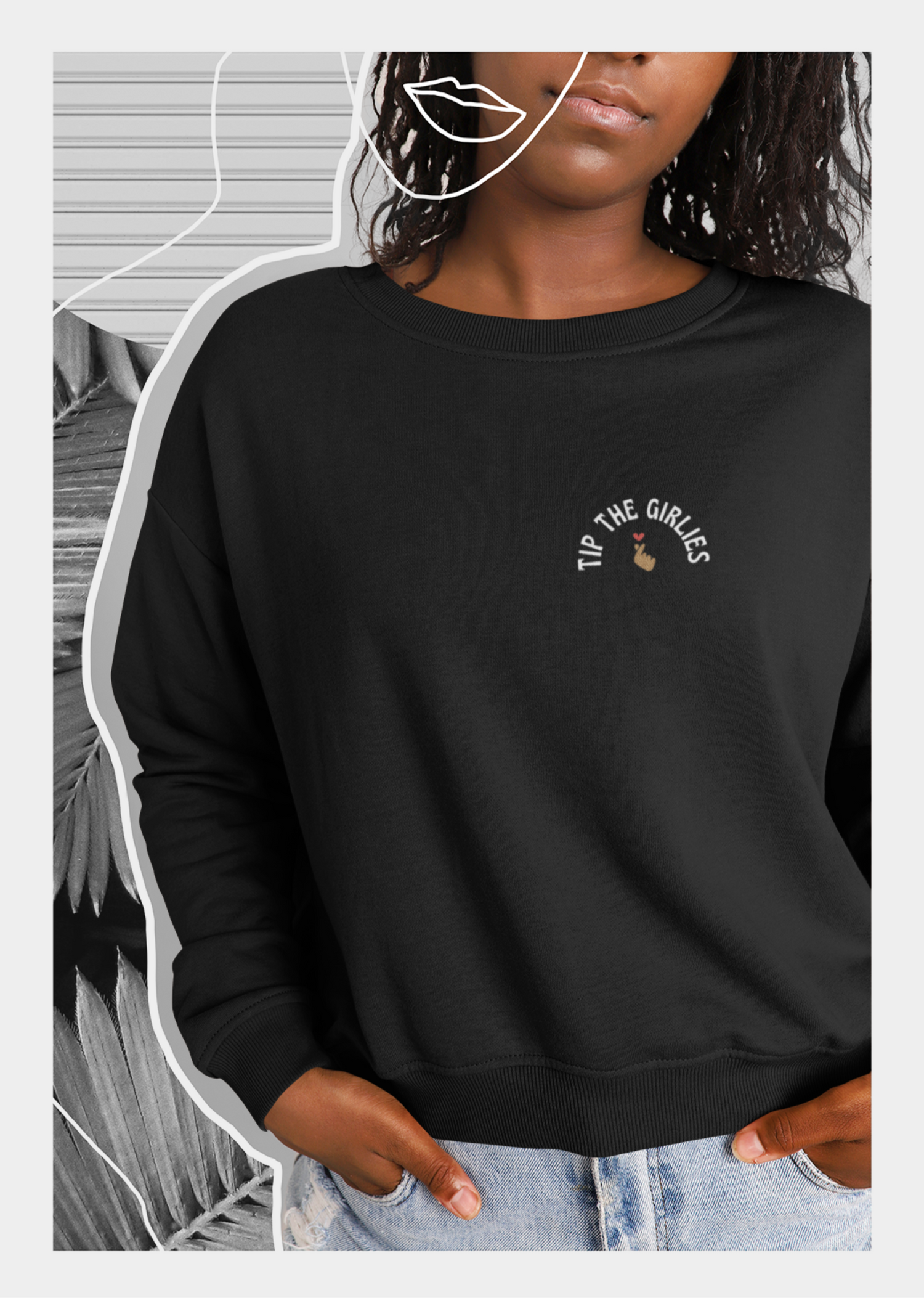 Woman wearing a black sweater with an embroidery saying "tip the girlies" on the left chest area. 