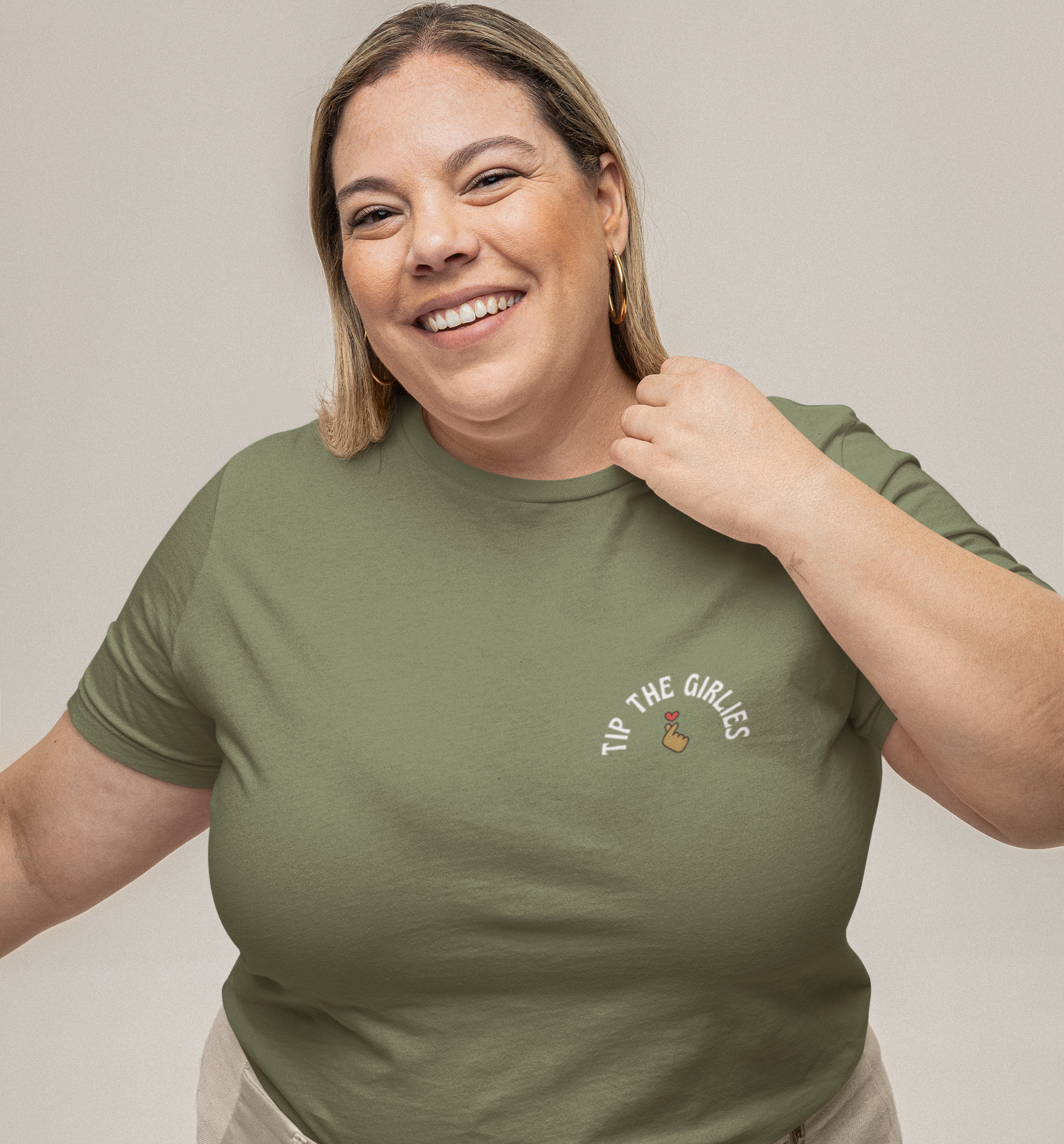 Woman in front of an off-white background wearing a green tshirt with the words 