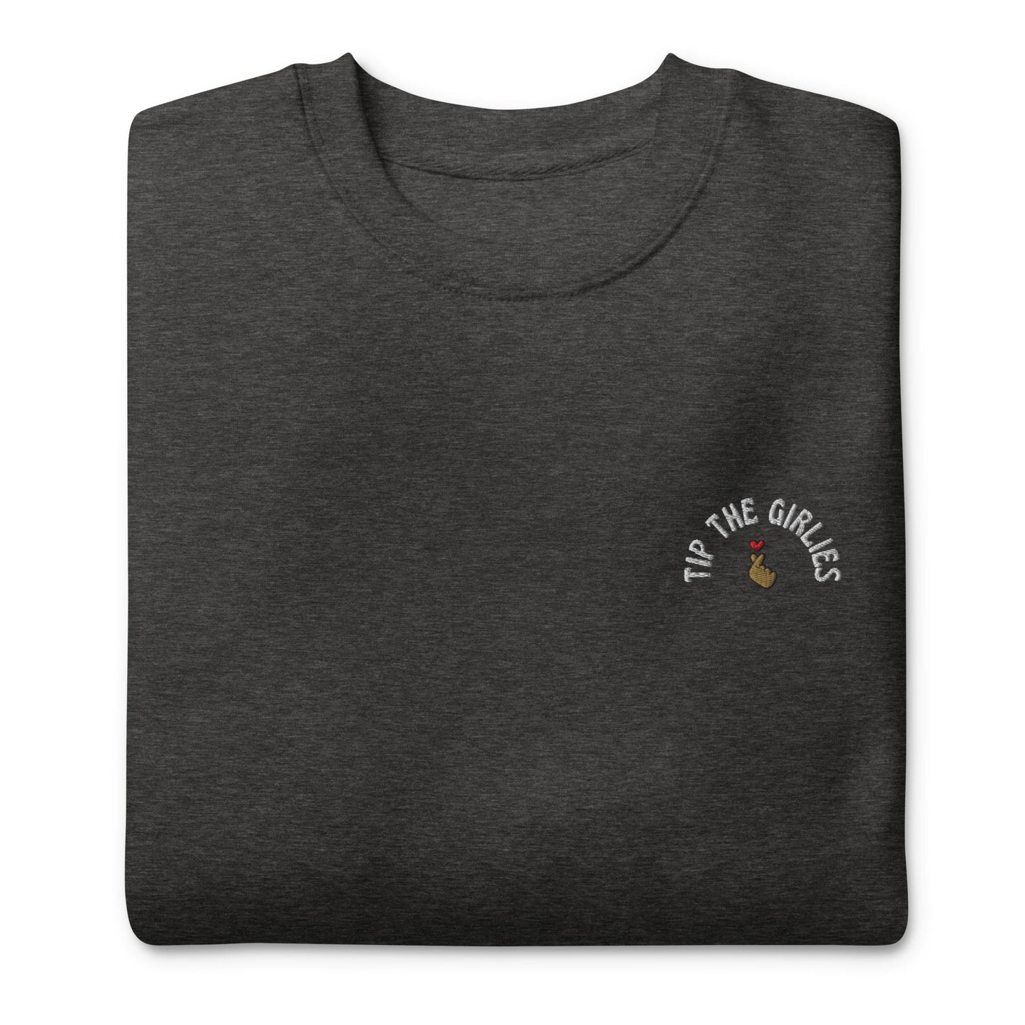 Folded dark grey sweater with the words "Tip the Girlies" embroidered on the left chest area, placed in front of a white background